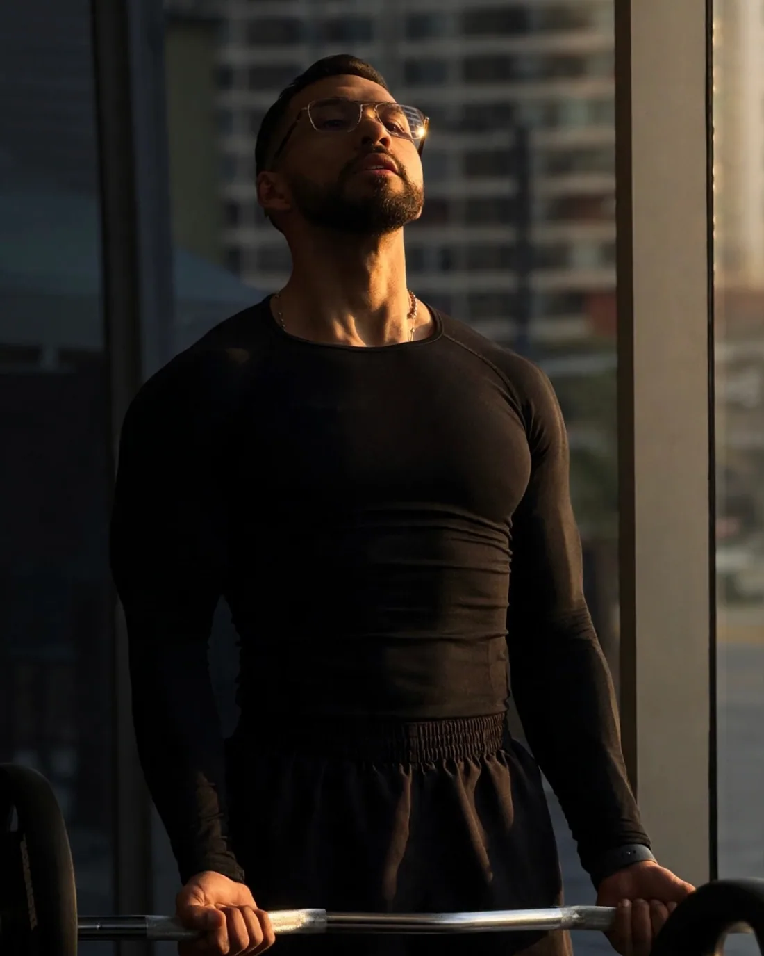 Marcos Pirona entrenando con barra junto al ventanal del gimnasio